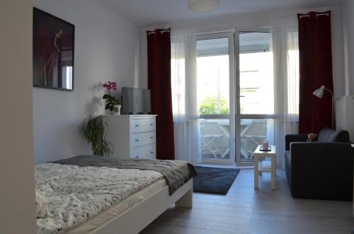 a bedroom with a bed and a sliding glass door at BAiGO STAR in Gdynia