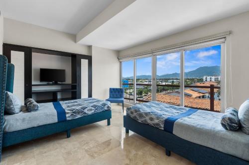 a bedroom with two beds and a large window at Deck12 Casino and Resort by Monyxbnb in Puerto Vallarta