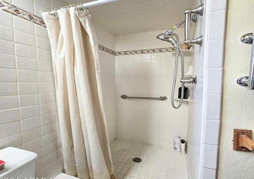 a bathroom with a shower with a shower curtain at Vigilante Inn Immortal Camp in Tombstone