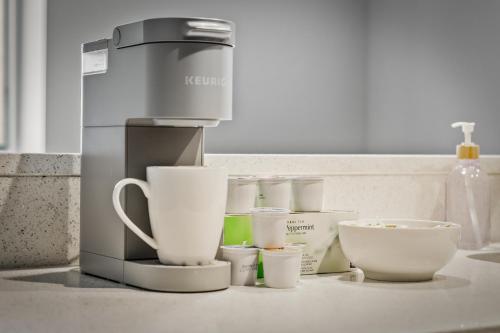 a coffee maker and cups sitting on a counter at Spacious DT Condo l Free Parking l Fast Wi-Fi in Cleveland