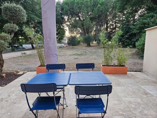 a blue table with four chairs around it at Appartement - mas provençal in Sernhac