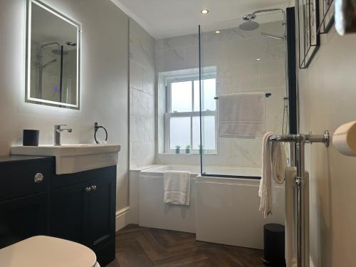 a bathroom with a sink and a tub and a shower at Church Walk View Apartment Filey in Filey