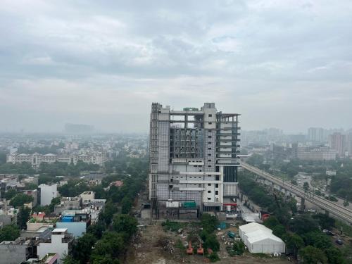 a tall building in the middle of a city at Nirvana by Urban Retreat Suite Near Expo Mart in Greater Noida