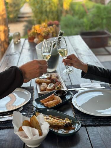 a table with two people holding glasses of white wine at La Guarda in Zapallar