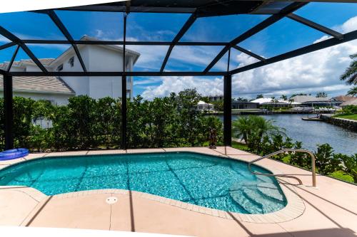 Marco Islandにある3 Bed 2 Bath Canal Home I Pool+Spa Gulf Accessの水辺の景色が見えるプール