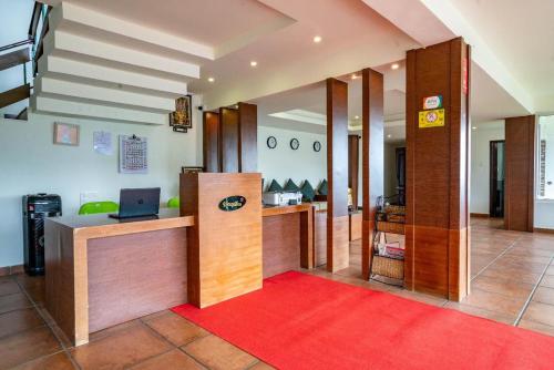 a lobby with a desk with a laptop on it at Shola Heaven Resort in Kanthalloor