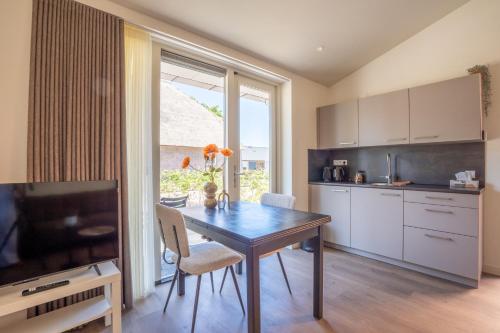 a kitchen with a wooden table and a dining room at Huis te Zeijen in Zeyen