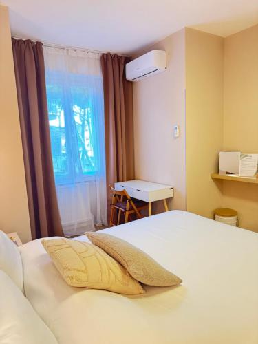 a bedroom with a white bed with a window at ELIOS LIVING - Modern comfort, walking distance to city center & 200m to the beach in Bordighera