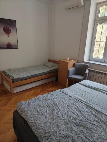 a bedroom with two beds and a chair in it at TARAS Hostel in Belgrade