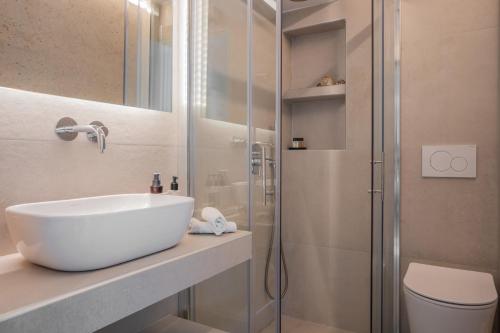 a bathroom with a sink and a shower at El Mar, Pool House with 3 BDR, 7 min from beach in Saronida