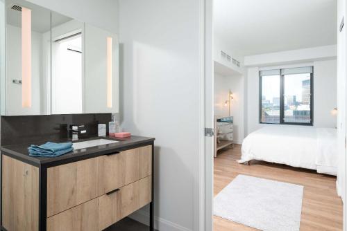 a bathroom with a sink and a bedroom with a bed at North End TD Garden Condo Shared Pool & Rooftop in Boston