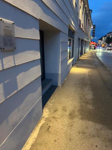 an empty sidewalk next to a white building at room4you Lambach in Lambach