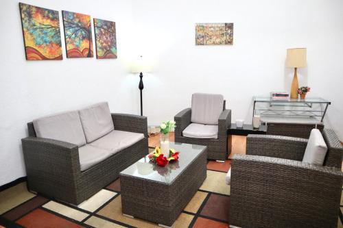 a living room with wicker chairs and a table at Linda Habitacion privada con balcon en Polanco in Mexico City