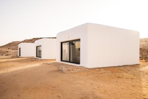 a row of white buildings on a dirt road at Desert Sands Dakhla Lagoon View & Kitesurf Spot in Dakhla