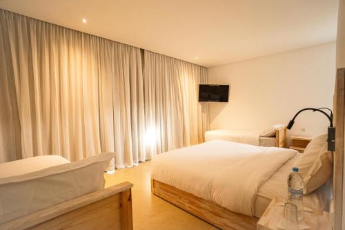 a hotel room with two beds and a television at Desert Sands Dakhla Lagoon View & Kitesurf Spot in Dakhla