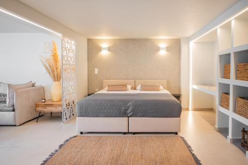a bedroom with a large bed and a couch at El Mar, Pool House with 3 BDR, 7 min from beach in Saronida