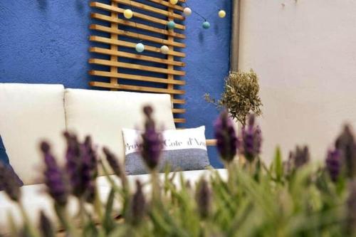 un bouquet de fleurs violettes devant un mur bleu dans l'établissement Le Limoni - Climatisé avec Patio privatif, à Brignoles