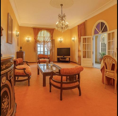 Una sala de estar con una mesa y sillas y un televisor. en Dar Kbira - Riad Azemmour, en Azemmour