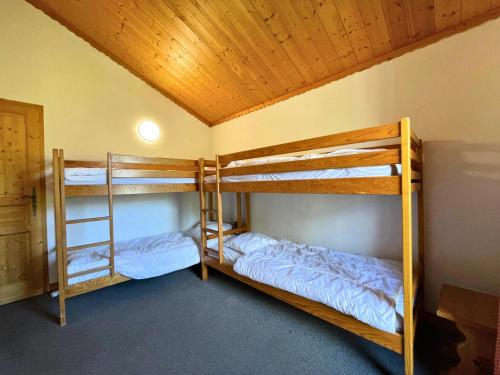 Cette chambre comprend 2 lits superposés et un plafond en bois. dans l'établissement Résidence Bosson - Magnifique appartement 12 personnes ski aux pieds MAE-3764, aux Menuires