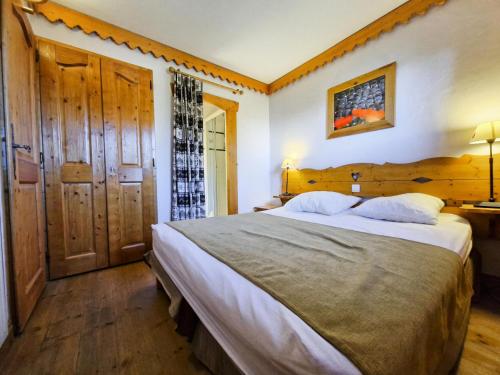 une chambre avec un grand lit dans une pièce dans l'établissement Résidence Roselend - Charmant appartement de 3 pièces situé dans une résidence au village du Chantel, proche des pistes et avec piscine. MAE-4441, à Arc 1800