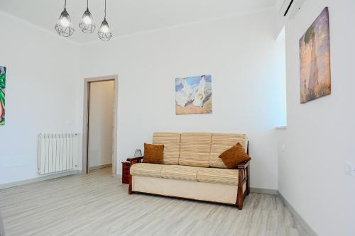 sala de estar con sofá y pinturas en la pared en Il Rifugio di Eva, en Alberobello