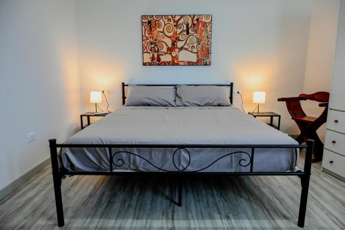 un lit dans une chambre avec deux lampes et un tableau dans l'établissement Il Rifugio di Eva, à Alberobello