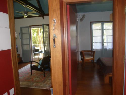 a room with a door open to a living room at Gîte de charme à Sainte-Rose, jardin créole, Wifi - FR-1-786-48 in Sainte-Rose