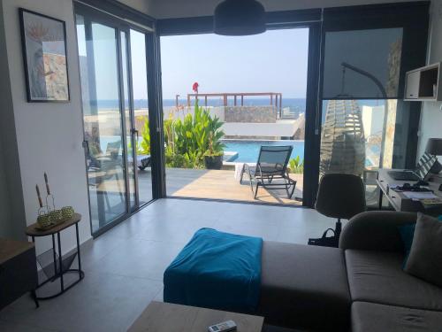 a living room with a couch and a view of a pool at Oceanfront Oasis with Private Pool Stunning Views in Kérynia