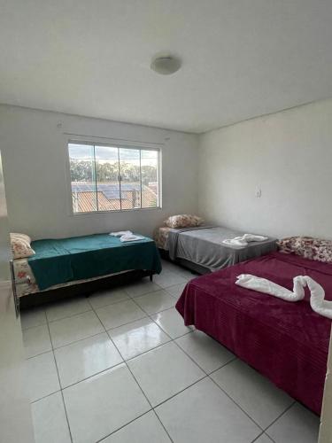 a room with two beds and a window at Casa na Suíça baina in Vitória da Conquista