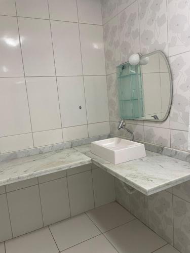 a bathroom with a sink and a mirror at Casa na Suíça baina in Vitória da Conquista