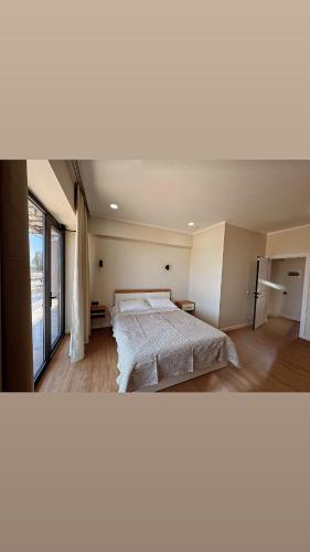a bedroom with a bed and a large window at Шатман люкс in Chyrpykty