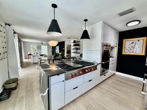 a kitchen with white cabinets and a stove top oven at Aylees Siesta Key Beach House-360 steps from beach-Saltwater Pool-Pet Friendly in Siesta Key