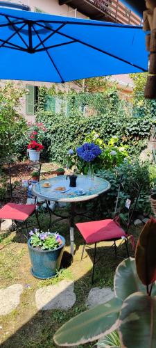a table with two chairs and a table with flowers at Casa di Rosa in Cureggio