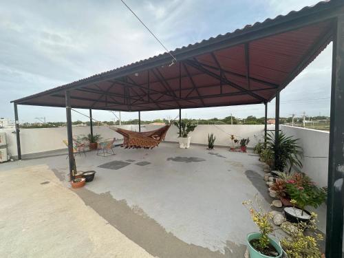 a patio with a red canopy on top of a building at hotel la casona in Maicao