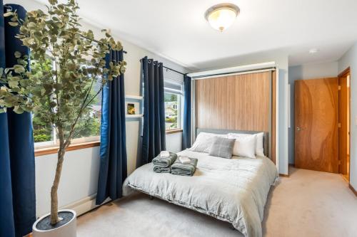 a bedroom with a bed and a potted tree at Magical Mountain Retreat in Juneau