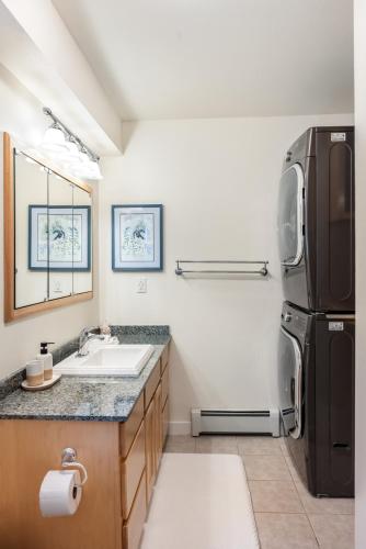 a kitchen with a black refrigerator and a sink at Magical Mountain Retreat in Juneau