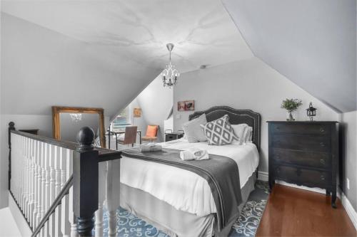 a bedroom with a bed and a staircase at 2BR Downtown Retreat Mins to Beach BBQ and Firepit in Cobourg