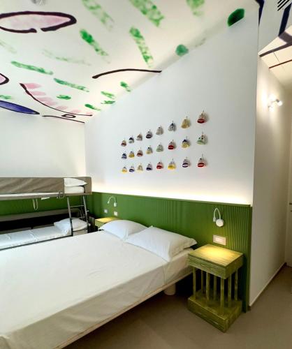 a room with a bed and a shelf with shoes on the wall at B&B Margherita Lido Marini in Lido Marini