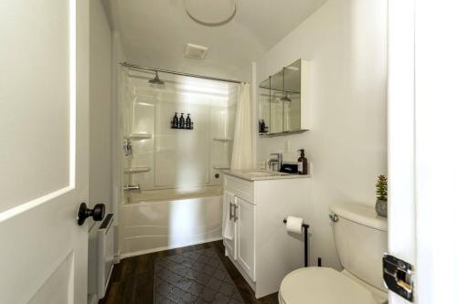 a white bathroom with a shower and a toilet at Cozy 2BR Apt near Downtown Free Parking and Wi Fi in Sudbury