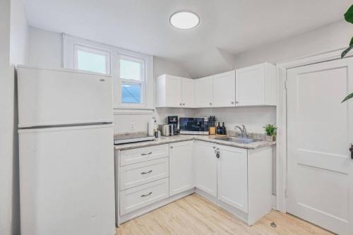 a kitchen with white cabinets and a white refrigerator at 2BR Apt Mins from Beach and Downtown Free Parking in Oshawa
