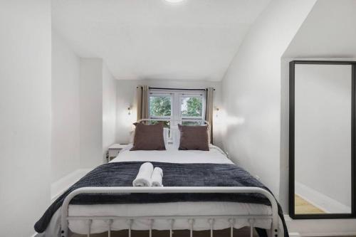 a white bedroom with a bed and a window at 2BR Apt Mins from Beach and Downtown Free Parking in Oshawa
