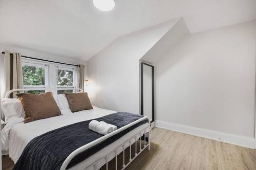 a white bedroom with a large bed with a window at 2BR Apt Mins from Beach and Downtown Free Parking in Oshawa