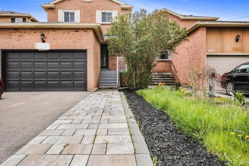 a brick house with a garage and a driveway at 3BR Pickering Retreat with BBQ and Patio Delight in Pickering