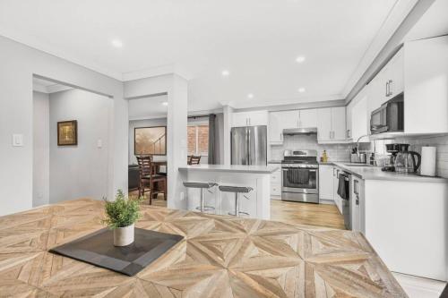 a large kitchen with white cabinets and a table at 3BR Pickering Retreat with BBQ and Patio Delight in Pickering