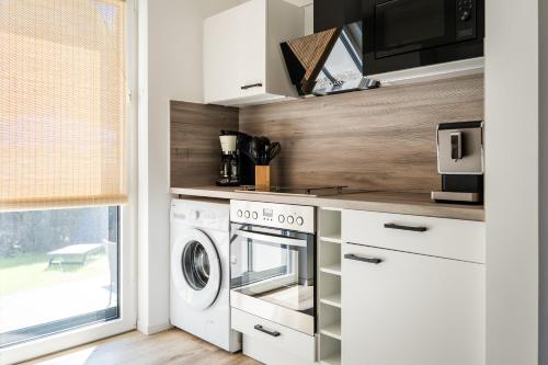une cuisine avec un lave-linge et un micro-ondes dans l'établissement Seeurlaub Haus Antonia, à Ferch