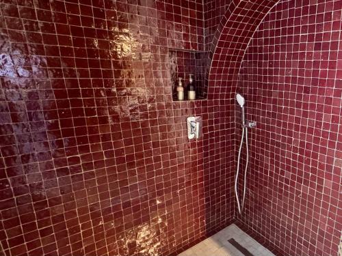 a red tiled bathroom with a shower in at Riad Zamane Fès - Boutique & Spa in Fès