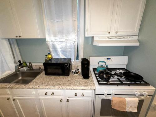 a kitchen counter with a stove and a sink at Wasabi Japanese Sanctuary 1BR minutes to the city in Jersey City