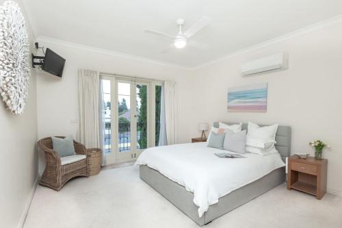 a white bedroom with a bed and a window at Beachside Warrnambool CBD in Warrnambool