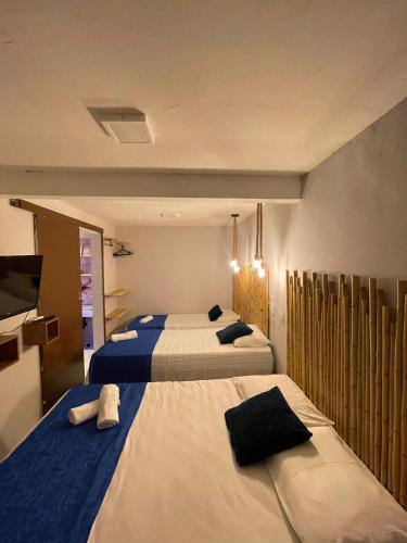 a bedroom with two beds and a tv on the wall at Residencial Temporada Aracaju in Aracaju