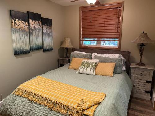 a bedroom with a bed with pillows and a window at Circle River Bungalow in North Bend